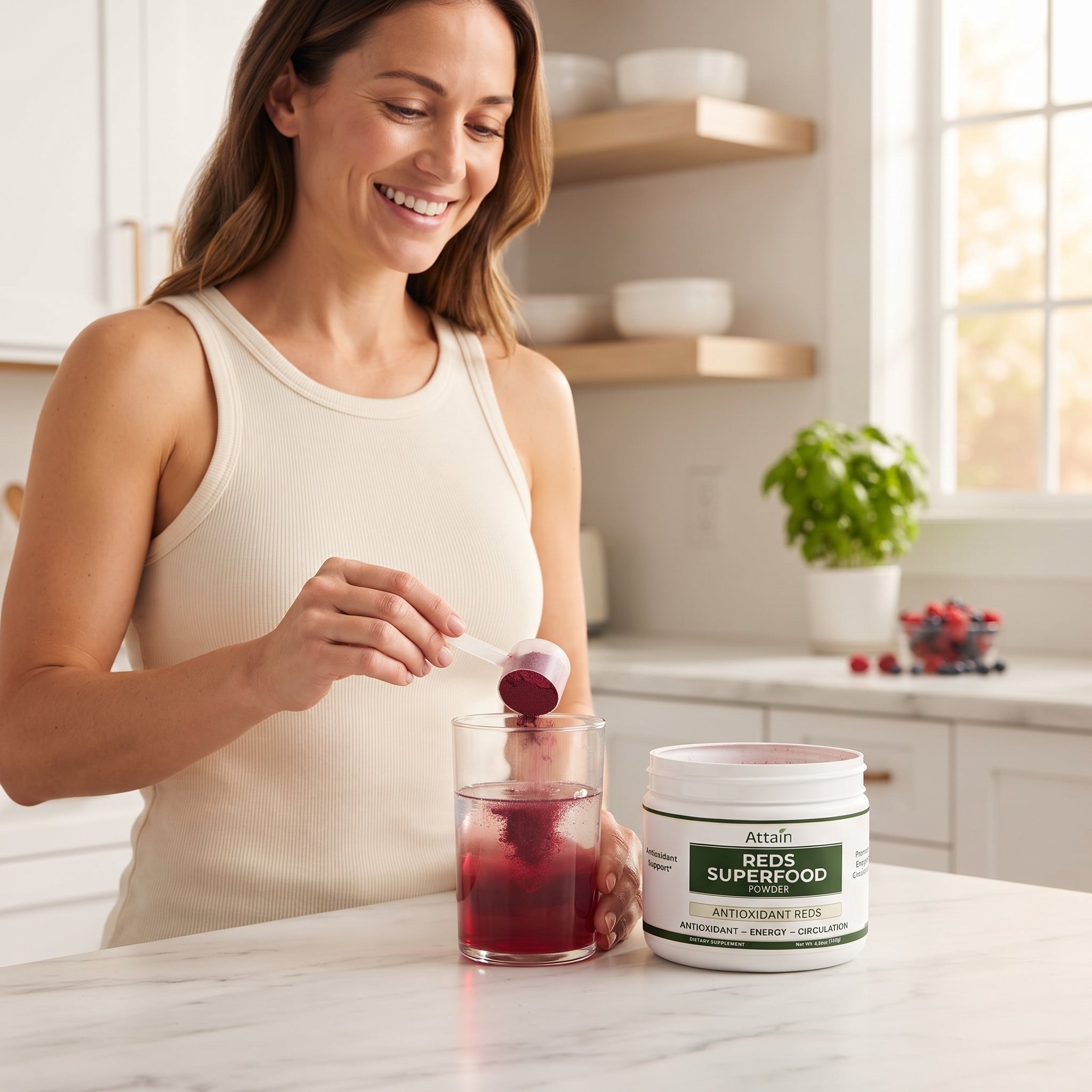 Woman scooping Attain Reds Superfood Powder into a drink | Attain Supplements